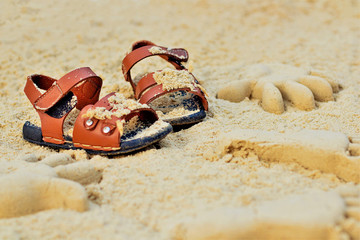 Sand on the beach or in the sandbox and footprints in the sand. Form for sand and children's shoes...
