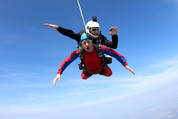 Fototapeta na wymiar Tandem skydiving. Two men are in the sky.