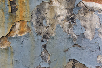 Blue paint peeling plaster gunge wall.
