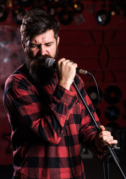 Man with enthusiastic face holds microphone, singing song,