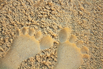 Sand on the beach or in the sandbox and footprints in the sand. Can be used as a background image to copy space.