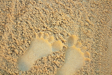 Fototapeta na wymiar Sand on the beach or in the sandbox and footprints in the sand. Can be used as a background image to copy space.