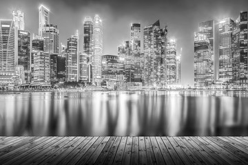 Empty wood plank with modern cityscape building at night in monochrome background for display or montage product.