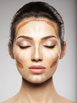 Cosmetic makeup tonal foundation is on woman's face.