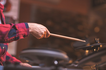 Male hands playing the drums indoors
