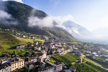 Little village in Valtellina, houses and vineyards, panoramic view from a drone. Italian Alps -...