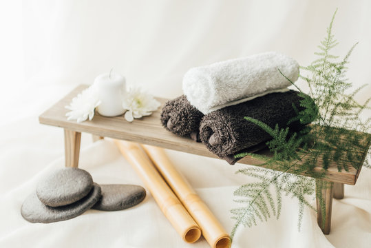 close up view of arrangement of spa treatment accessories with towels and pebbles on white background - Powered by Adobe