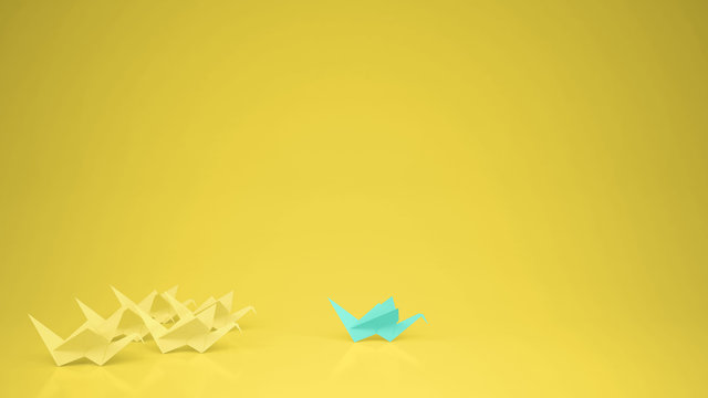 Origami turquoise paper crane leading group of cranes, leadership motivation concept idea with copy space, yellow background