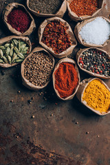 top view of colorful spices in paper bags on table