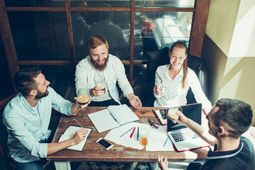 Young cheerful people smile and gesture while relaxing in pub.