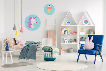 Sweet bedroom interior for a kid with a blue armchair, rabbit pillow, bed, unicorn and ice cream...