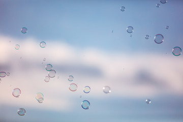 Soap bubbles in flight against the sky