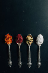 top view of salt, saffron and chili pepper spices on table