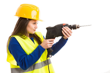 Young female engineer using drilling machine.