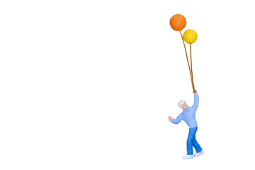 Miniature people holding balloon isolated with clipping path