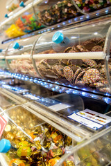 Offer sweets in transparent boxes in the store. Racks full of candy.