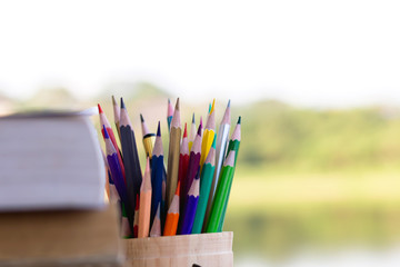 books and colorful pencils on wooden table lake background,Education concept.