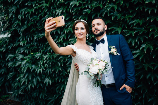 Beautiful young wedding couple outside in nature on leaves background - Powered by Adobe