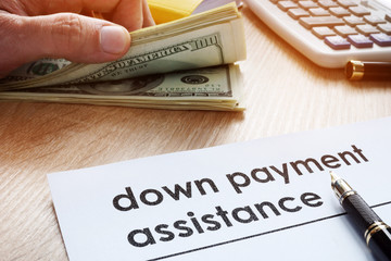 Down payment assistance form and dollar banknotes.