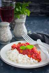 Flounder with tomato sauce and boiled rice, selective focus