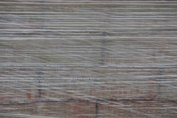 texture of transparent gray cellophane in water drops on bricks