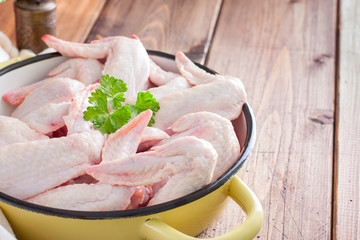 Raw chicken wings on a wooden table, horizontal, copy space