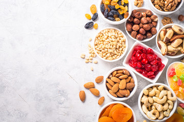 Nuts and dried fruits assortment on stone table top view. - obrazy, fototapety, plakaty