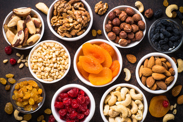 Nuts and dried fruits assortment on stone table top view.