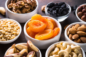 Nuts and dried fruits assortment on stone table top view.