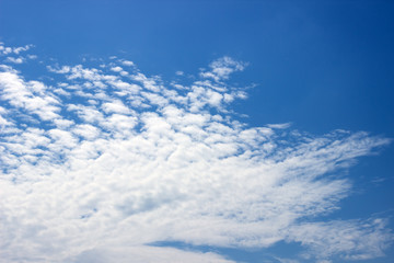 Fototapeta premium Fluffy white clouds on a blue sky. Clear sunny day. Background.