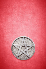 Wiccan and witchcraft pentagram on a textured red background with space for copy and text