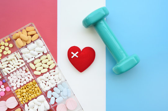 close up of different medication with red heart and dumbbell for background