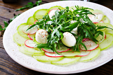 Carpaccio of radish with arugula, mozzarella and  sauce. Healthy food. Daikon salad