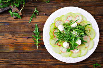 Carpaccio of radish with arugula, mozzarella and  sauce. Healthy food. Daikon salad. Flat lay. Top view