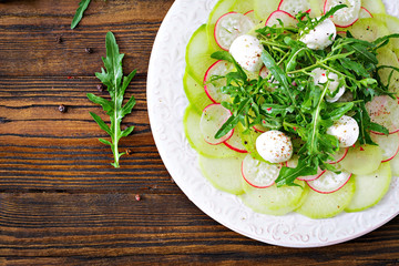 Carpaccio of radish with arugula, mozzarella and  sauce. Healthy food. Daikon salad. Flat lay. Top view