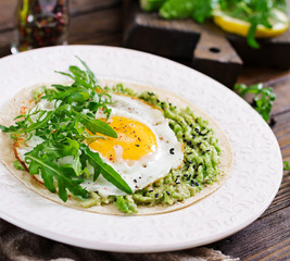 Tacos with guacamole, fried egg and arugula. Healthy food. Useful breakfast.