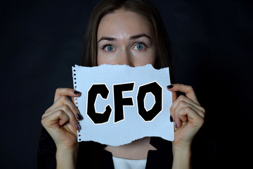 In the hands of a businessman a scrap of paper with the inscription:CFO