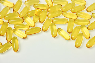 Fish oil capsules close up view on white background.