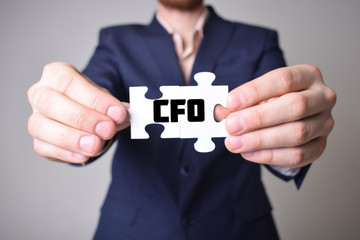 Businessman holding a puzzle with the inscription:CFO