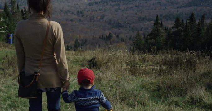 Mother and toddler son walking down mountain - pause to look