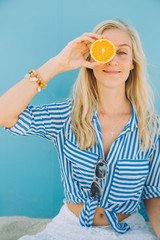 Young happy woman posing with orange half