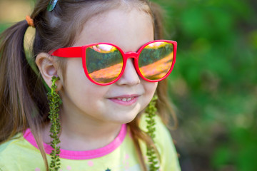 The girl tries on on herself earrings from a tree