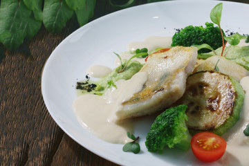 cod fish with broccoli close up on dark wooden background