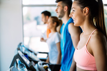 Fototapeta na wymiar Healthy man and woman running on a treadmill in a gym