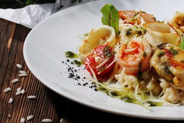 risotto with seafood close up on dark wooden background