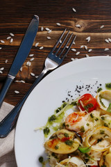 risotto with seafood and cutlery on dark wood