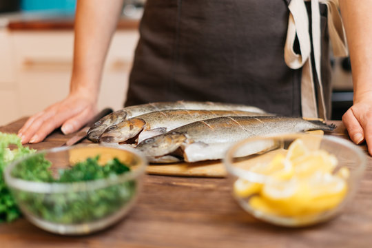 Woman Will Cook Fish Dish In Kitchen.