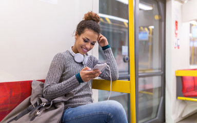 Young woman using mobile phone on subway
