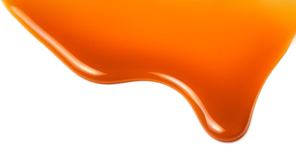 Sweet caramel sauce drop  isolated on white background close up. Golden Butterscotch toffee caramel...