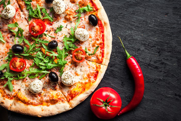  Margarita pizza with  mozzarella cheese, cherry tomatoes on black stone background,  copy space...